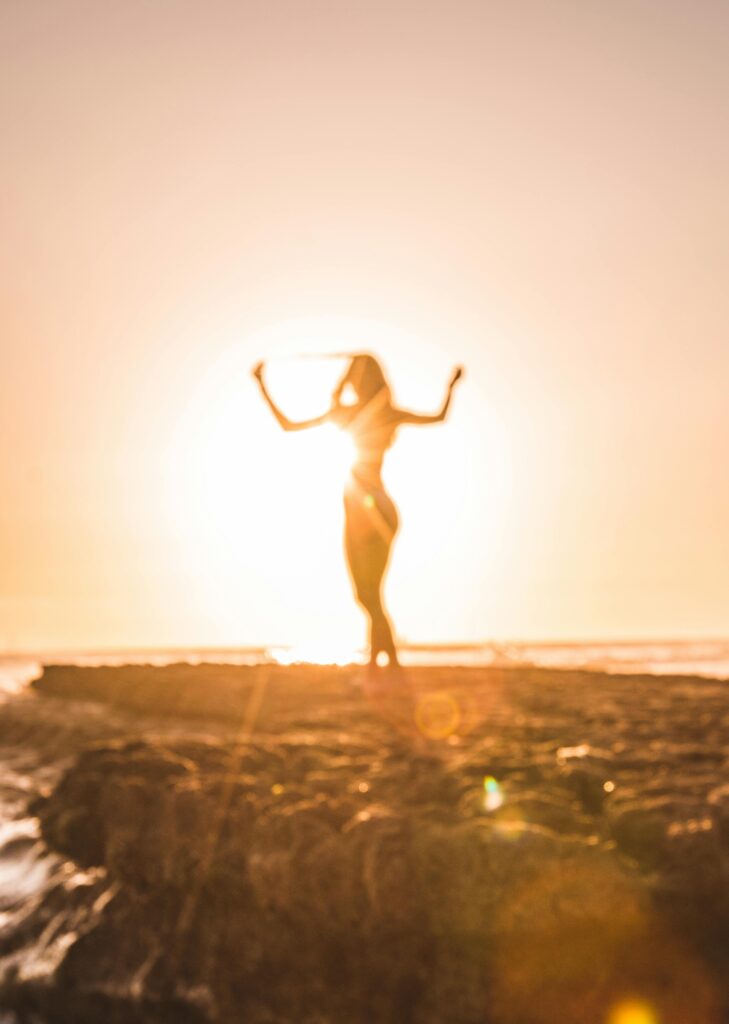 pexels-photo-1168744-1168744 A woman celebrates at sunset on a beach in San Diego, creating a stunning silhouette.
